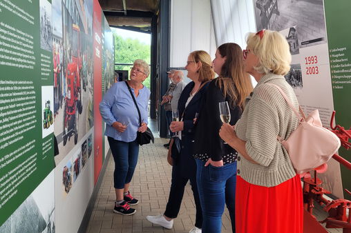 Einige Besucher sehen sich eine Informationstafel des Agroneums an