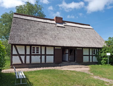 ein altes reetgedecktes Fachwerkhaus auf dem Außengelände des Agroneum
