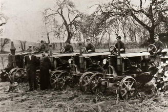 5 historische Automobile in einer Reihe, auf jedem Fahrzeug sitzt ein Mann