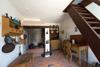 Küche mit offenem Kamin, die das Wohnumfeld einer Landarbeiterfamilie um 1900 zeigt.