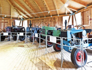 5 grüne und blaue alte Traktoren ausgestellt im Traktorenpavillon