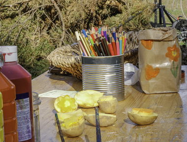 Ein Tisch mit Bastelmaterialien, Buntstiften, Pinseln und Kartoffeln