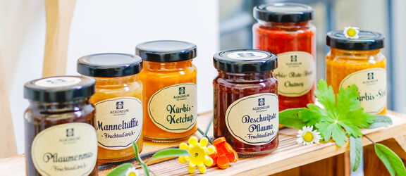 Ein Holzregal mit verschiedenen Sorten von Marmeladengläsern des Agroneums